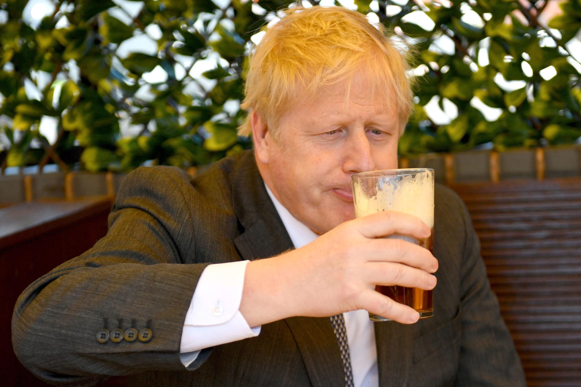 Premiärminister Johnson smuttar på en pint öl i trädgården under ett besök på The Mount pub och restaurang i Wolverhampton den 19 april 2021.