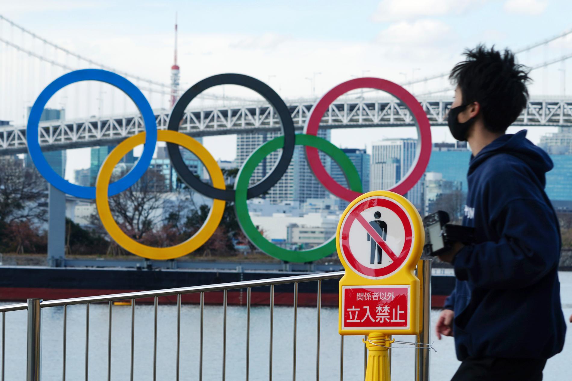 En man med munskydd nära OS-ringarna i Tokyo. Arkivbild.