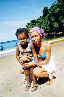 På stranden Macqueripe utanför Port of Spain på Trinidad poserar Carol-Ann George med dottern Paul-Ann.