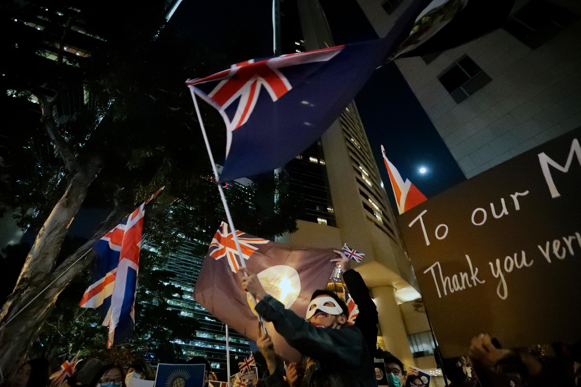 Demonstranter viftar med brittiska flaggor utanför brittiska konsulatet i Hongkong.