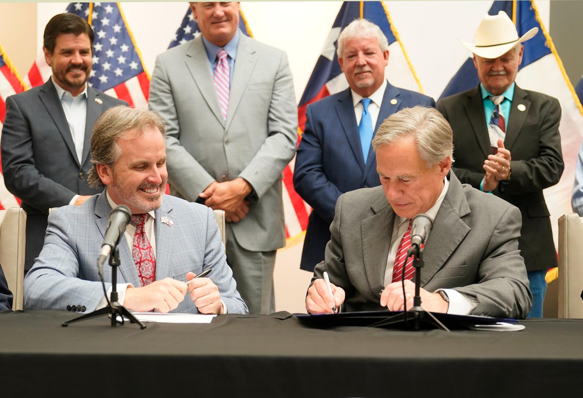 Texas guvernör Greg Abbott (till höger) signerar den nya vallagen.