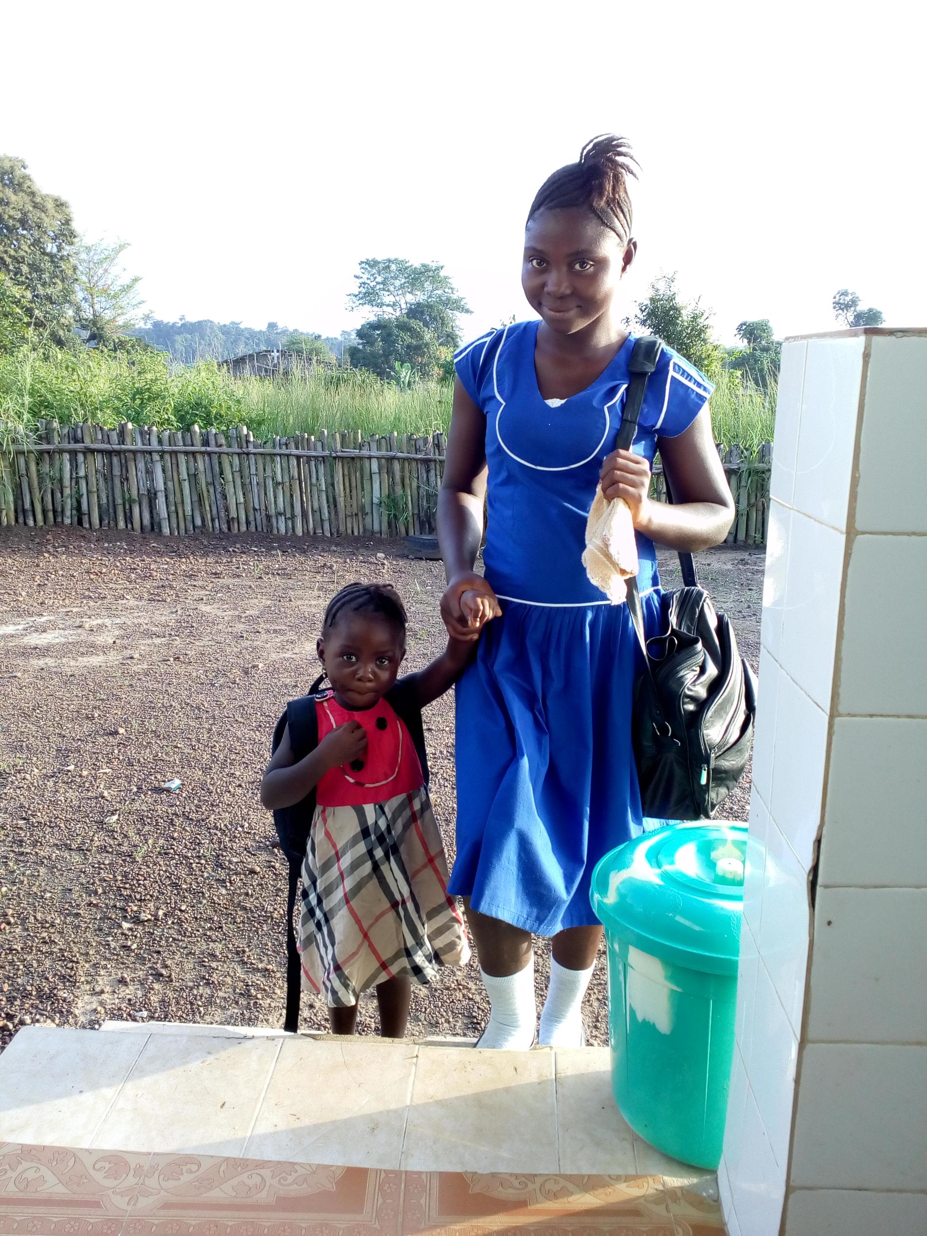 Lombeh M Sillah med sin dotter Anointina. Dottern är på daghem medan Lombeh är i skolan.