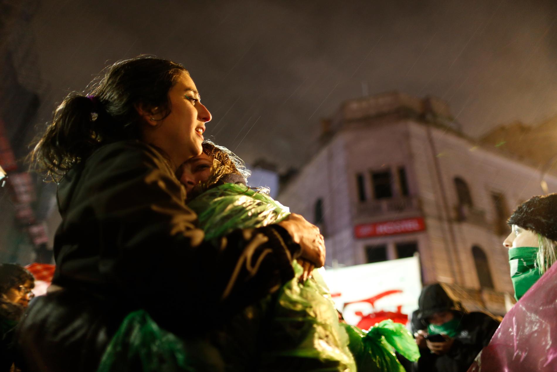 Tamara Deisel kramas om av vännen Florencia Buena, båda aborträttsförespråkare, medan de står i regnet utanför kongressen i Buenos Aires och väntar på omröstningen.