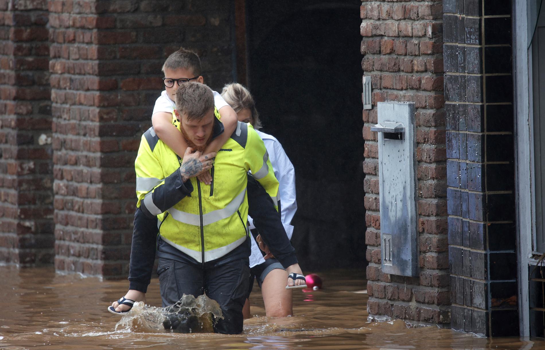 En räddningsarbetare hjälpte under torsdagen de boende i belgiska Pepinster att evakueras från översvämningarna.
