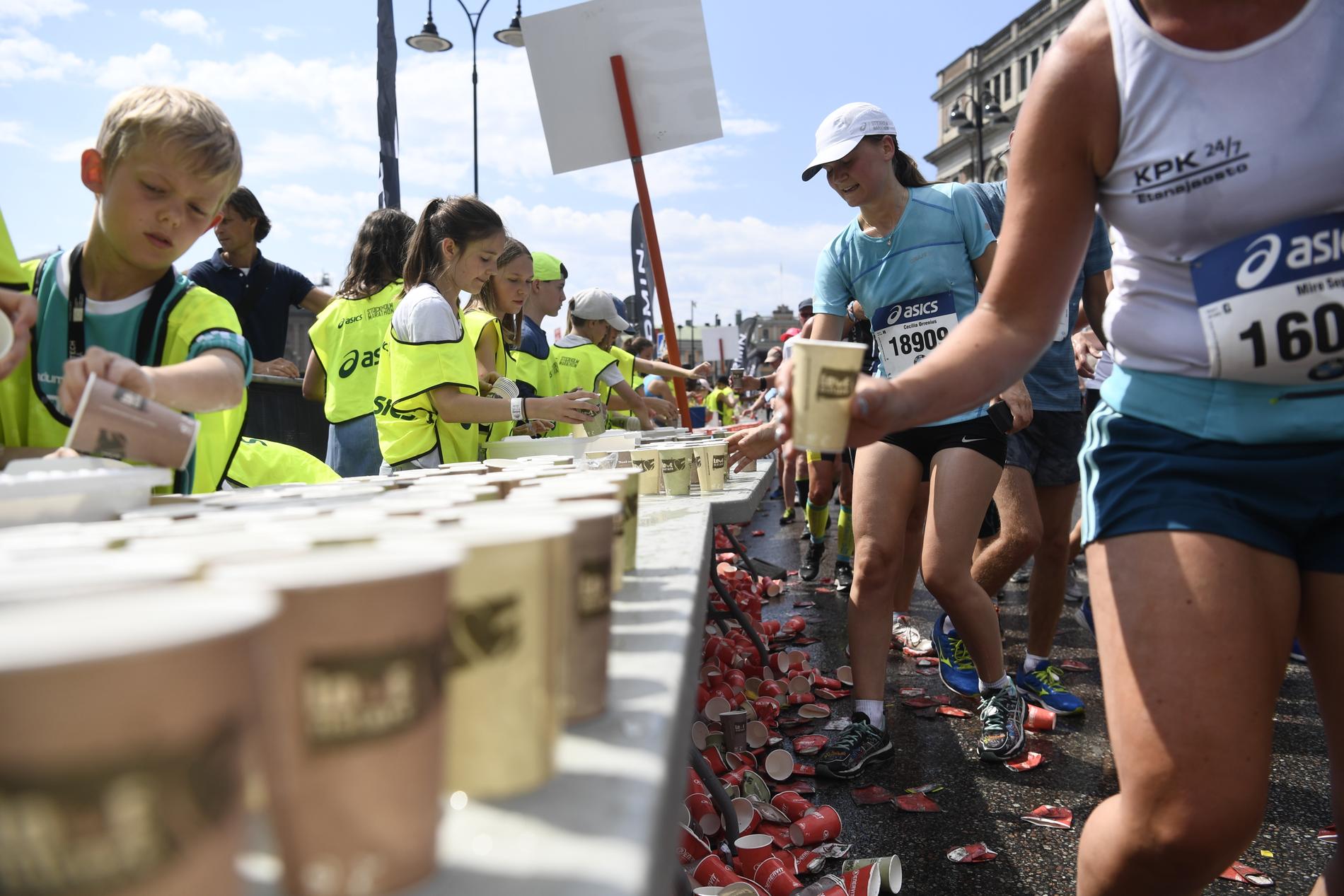 Löpare tar vatten och sportdryck i en vätskedepå under fjolårets Marathon. Arkivbild.