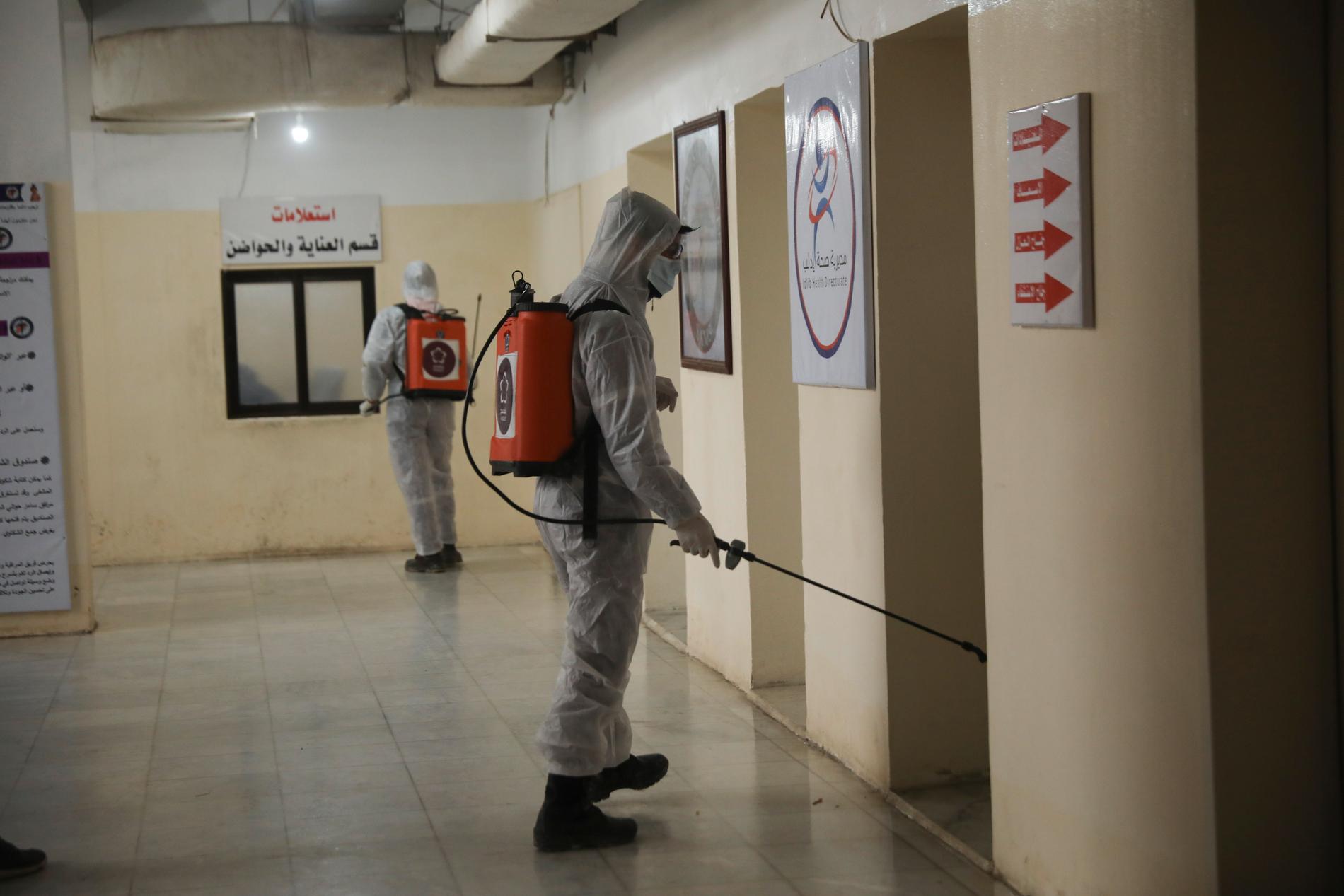 Anställda hos en hjälporganisation desinfekterar sjukhuset Ibn Sina i staden Idlib i norra Syrien.