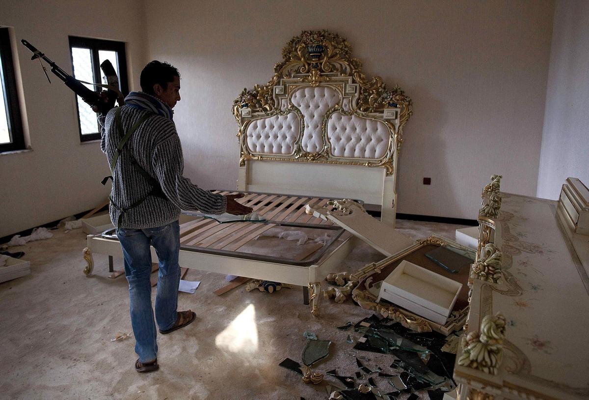 guldsäng En libysk motståndsman visar Muammar Gaddafis privata sovrum på flygplatsen i Benghazi. Rummet användes av diktatorn och hans familj när de reste.