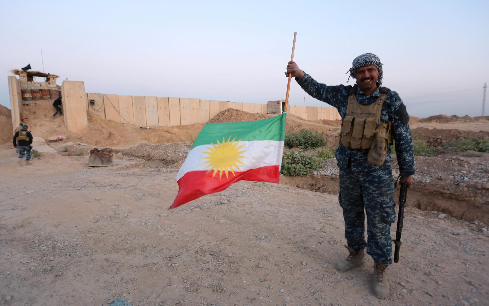 En irakisk soldat håller en upp-och-nedvänd flagga.