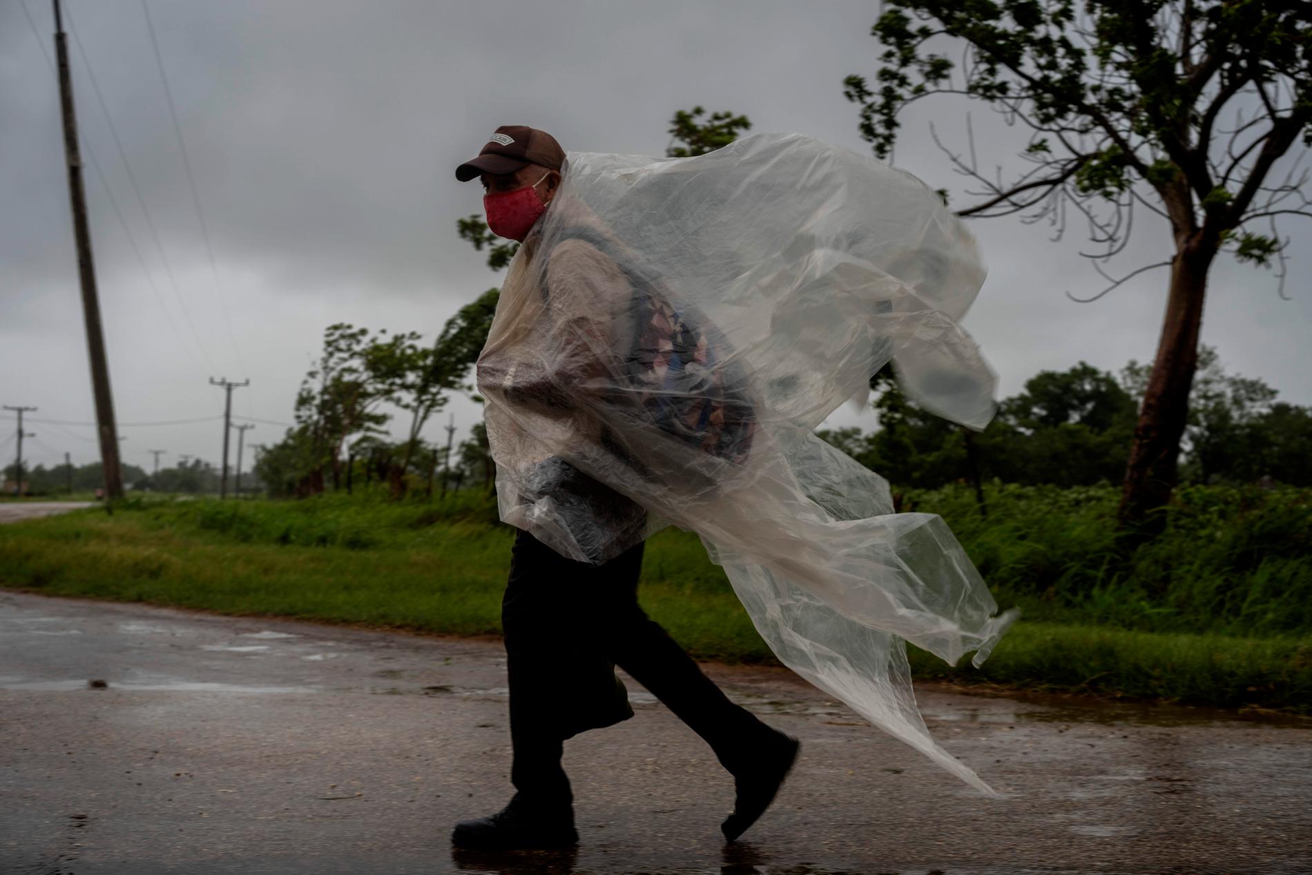 En man i Batabano i Kuba skyddar sig mot regnet när Ida nådde landet. 