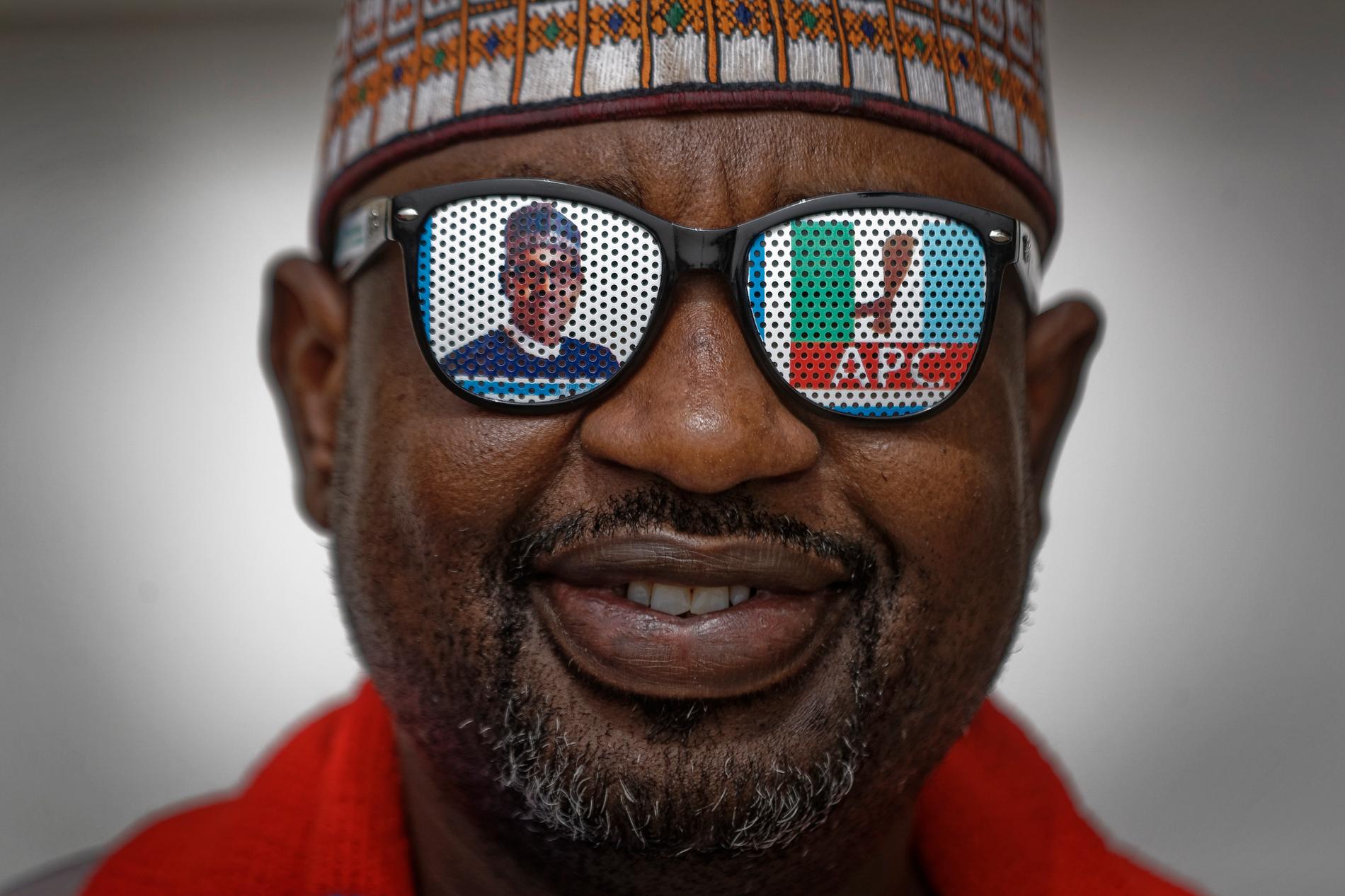 Valfeber i Nigeria. En man som stöder sittande president Muhammadu Buhari har fixat till sina solglasögon.