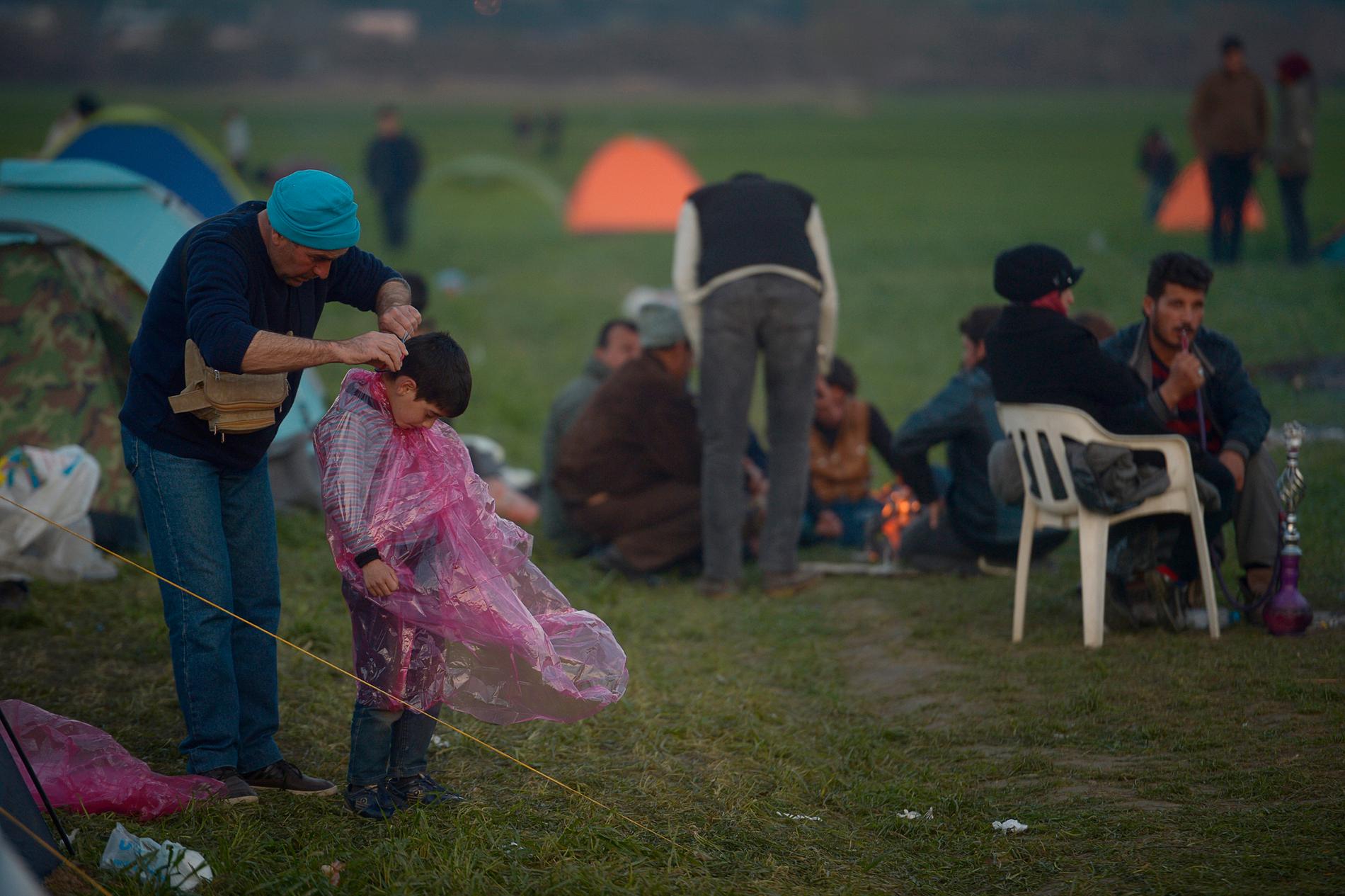 Det är dags att gå och lägga sig i flyktinglägret vid gränsen mellan Grekland och Makedonien. Efter att solen försvunnit bakom bergen tar det bara en halv timme till det att det är helt mörkt i lägret. Man släpar sina nyinköpta tält och sätter upp dem på någon av åkrarna vid gränsen. Man eldar kvistar, grenar och skräp för att hålla värmen.
