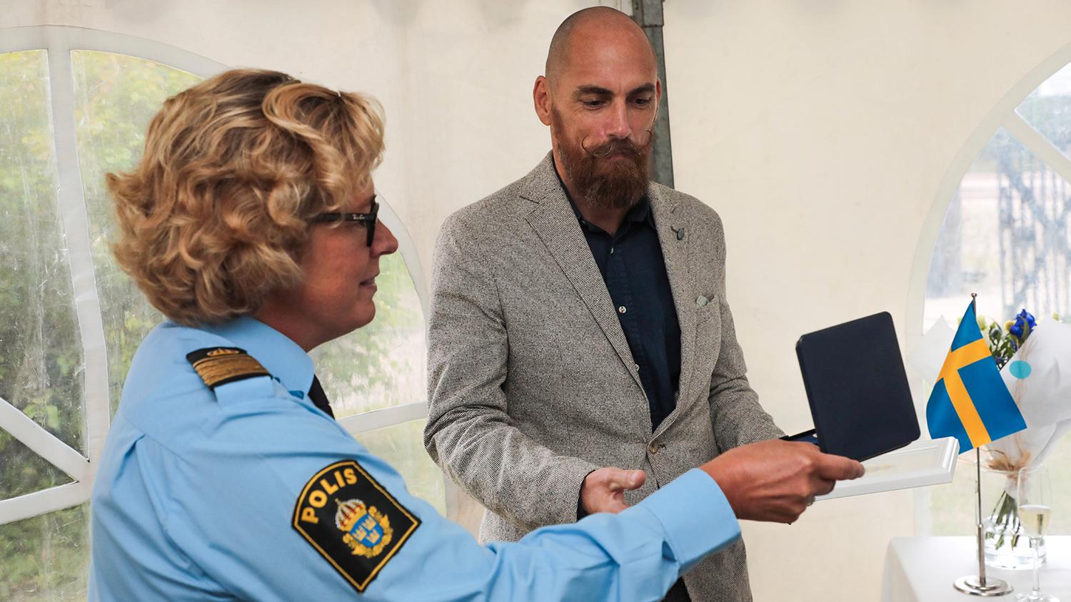 Carina Lennquist, biträdande regionpolischef, överlämnar Polismyndighetens Medborgarmedalj till Roger Petersson.
