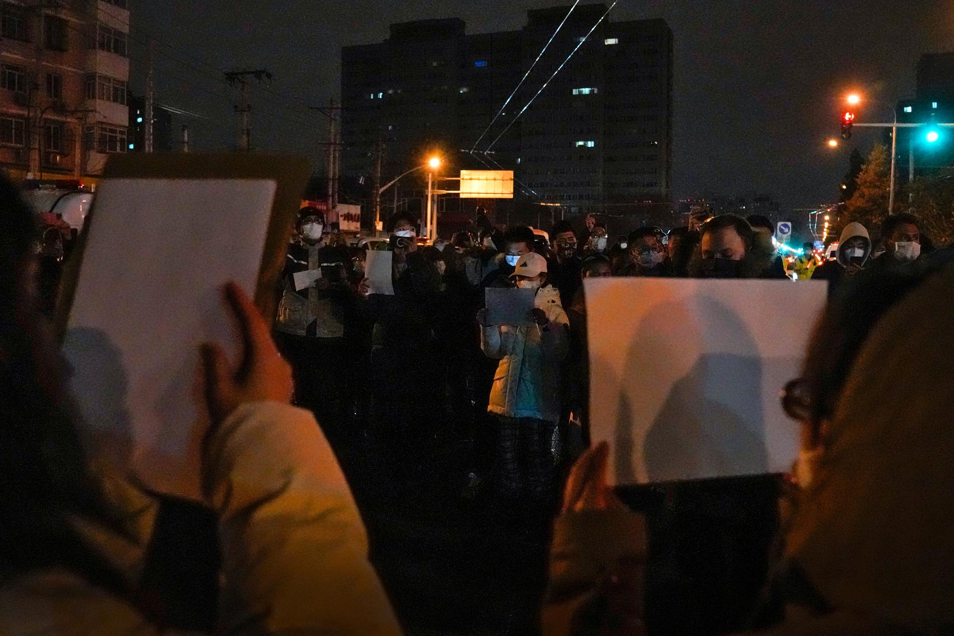 Tomma A4-papper hölls upp vid en demonstration mot covidrestriktionerna i Kina, i huvudstaden Peking i söndags.