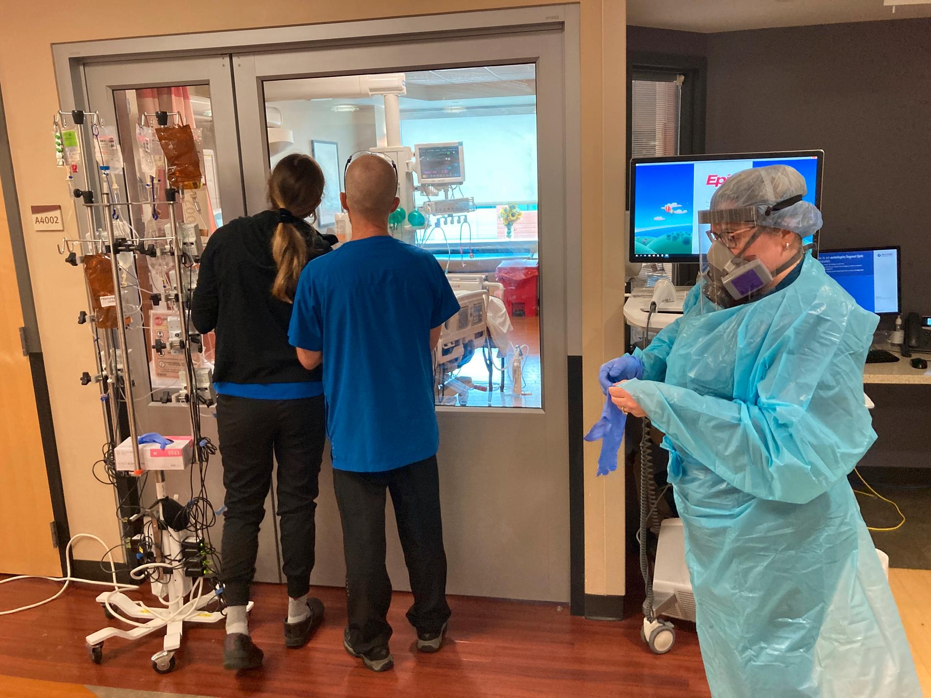 Två besökare tittar genom en glasruta in i en intensivvårdsenhet på ett sjukhus i Salem i Oregano i USA. Bilden är från den 20 augusti.