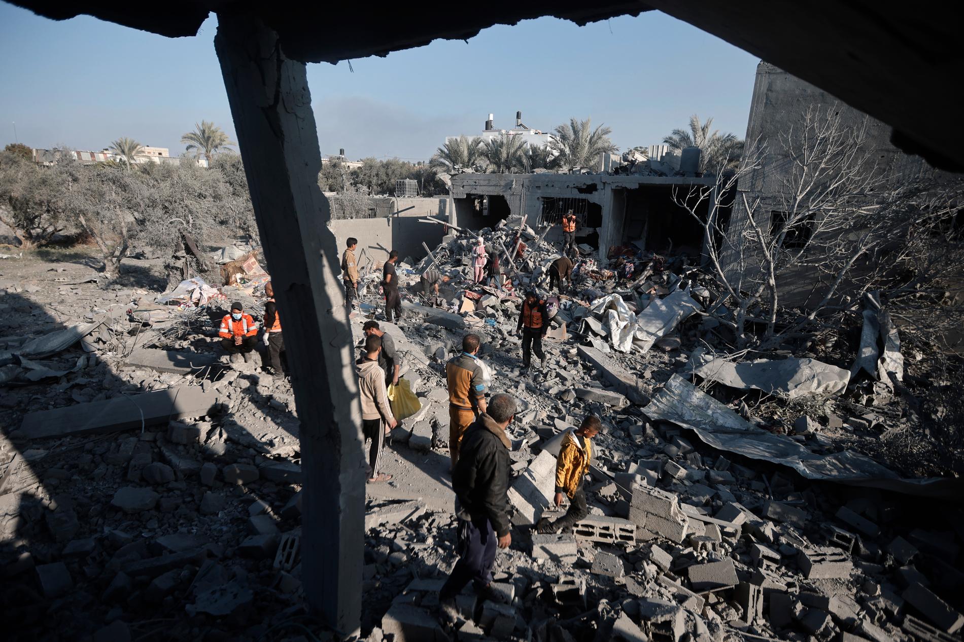 Palestinier i Khan Yunis i södra Gaza betraktar resterna av ett hus som bombats av israeliskt stridsflyg. Bilden togs på nyårsafton.