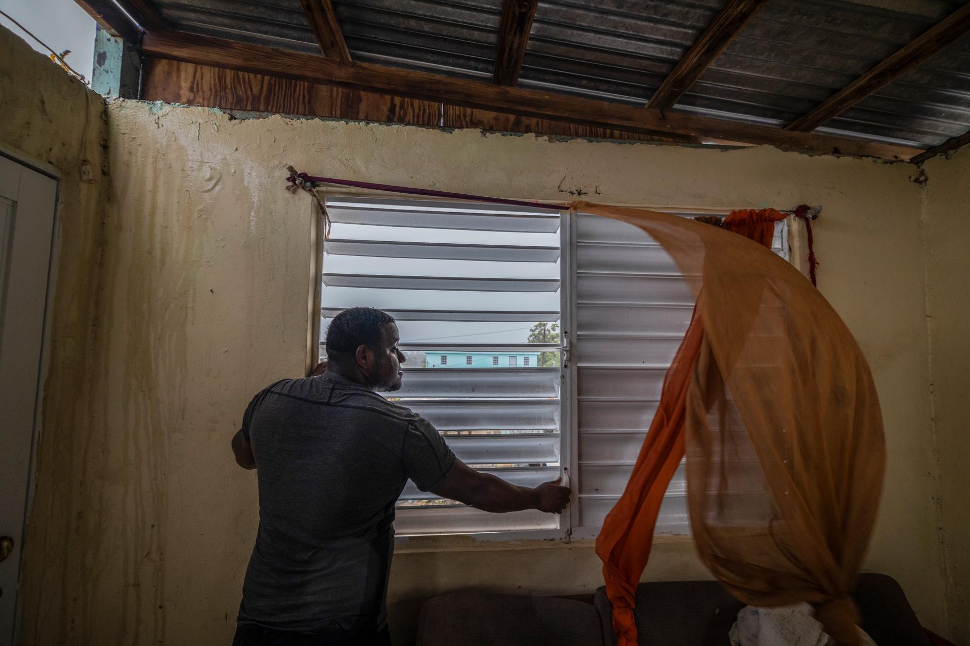 En man säkrar sitt fönster inför orkanen.