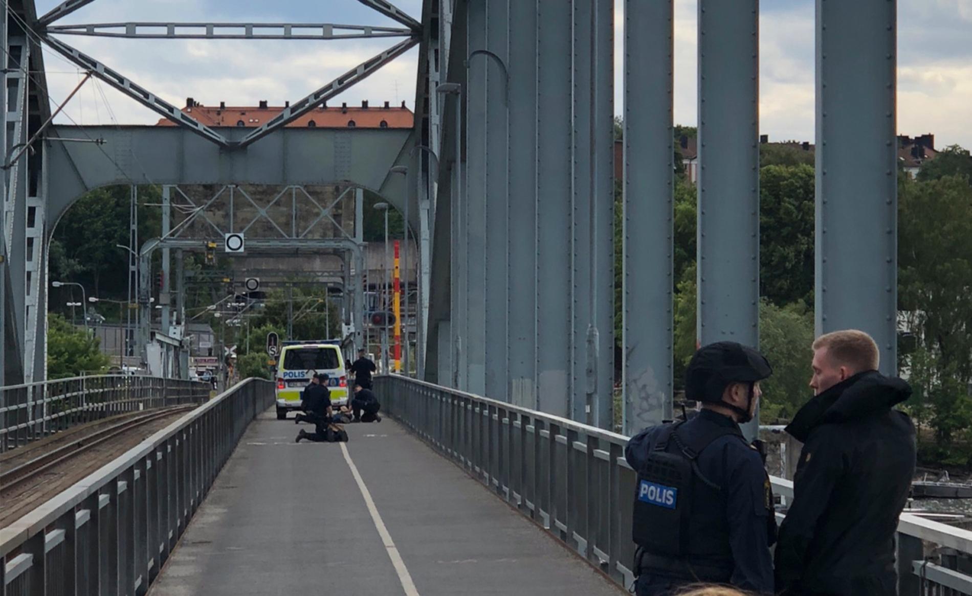 Polisen griper en person på bron.
