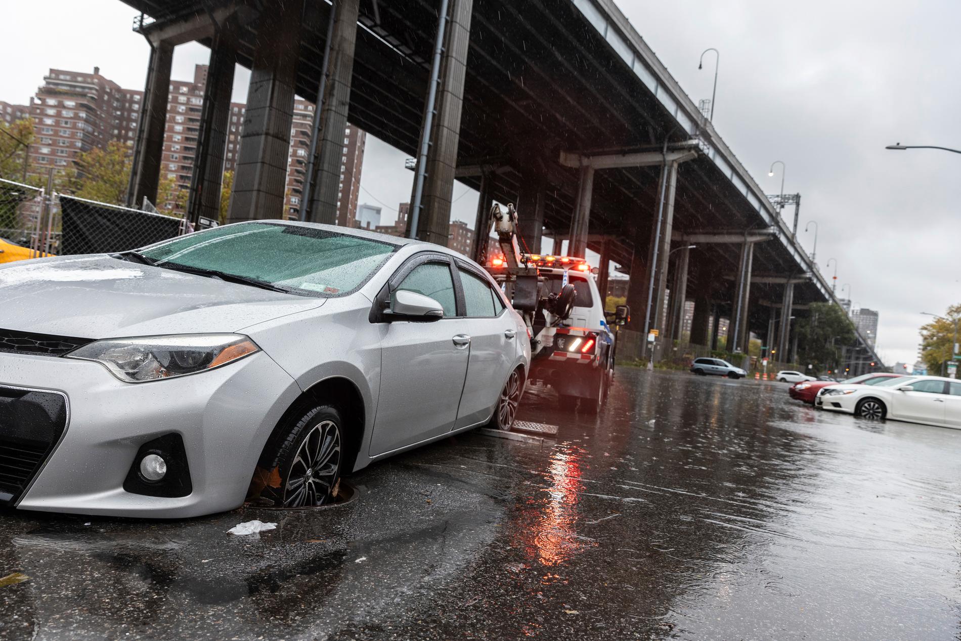 En bil bogseras bort vid Williamsburgs bridge under översvämningarna på Manhattan i New York i september förra året. Tunnelbanan och rälstrafik stängdes av och gator och motorvägar svämmade över och på La Guardia-flygplatsen försenades flyg på grund av översvämningarna.
