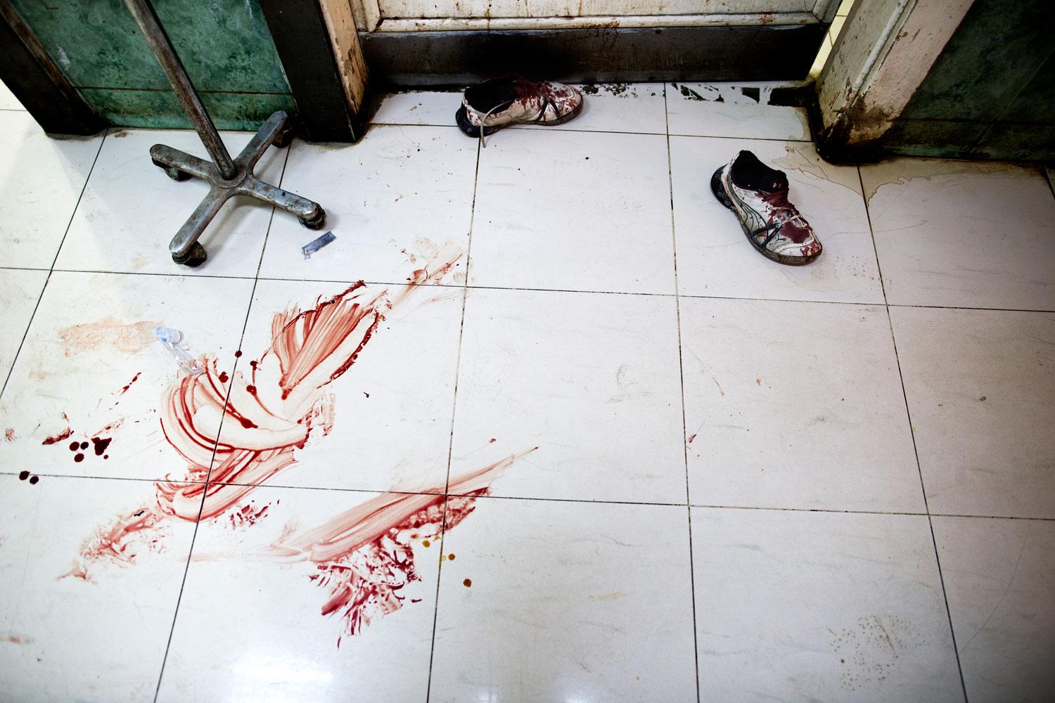 Golvet på Dar al-Shifa-sjukhuset är täckt av blod. Ett par blodiga gympaskor står utanför operationsrummet.