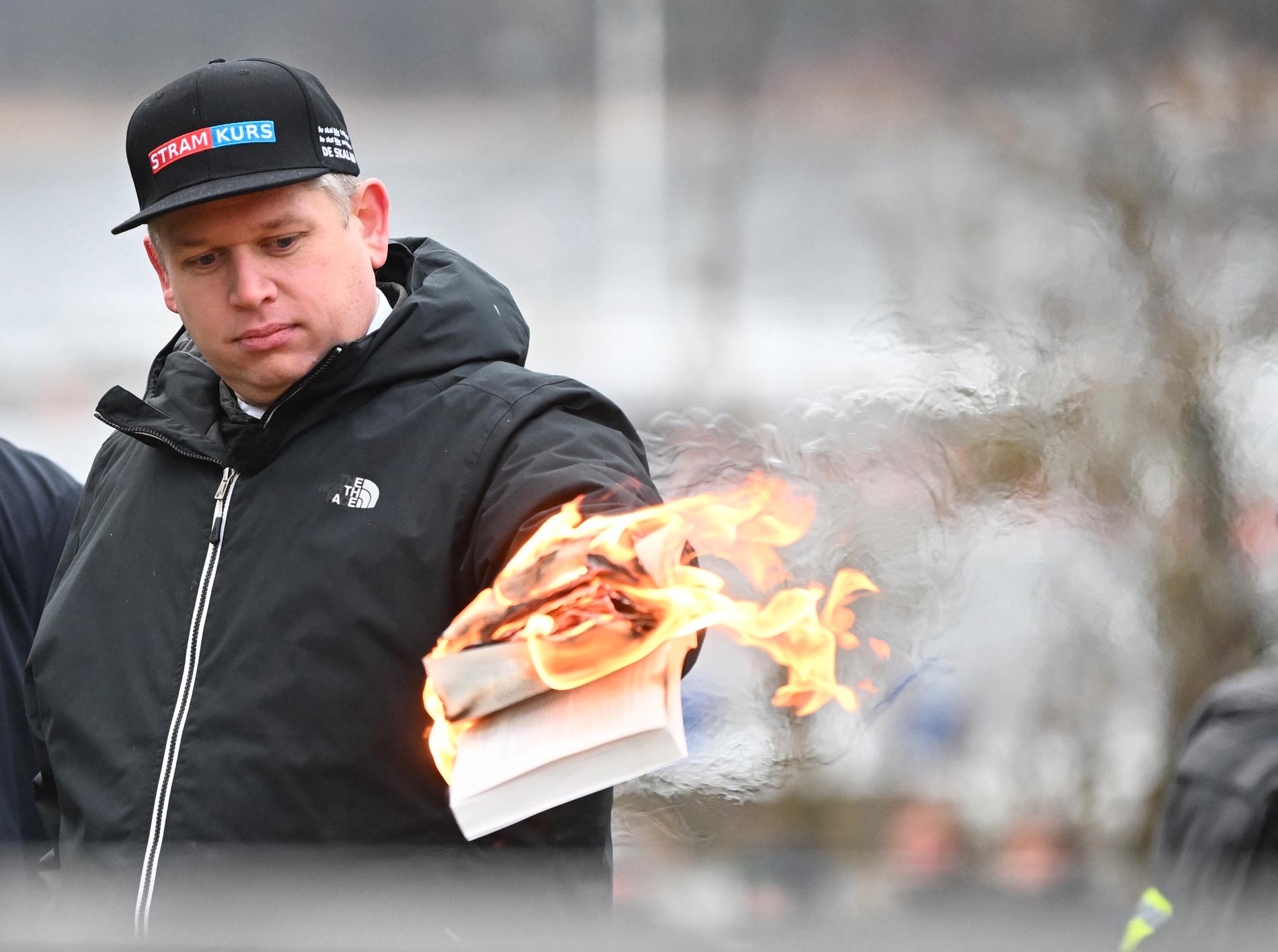 Rasmus Paludan bränner ett exemplar av Koranen i närheten av Turkiets ambassad i Stockholm under lördagen.