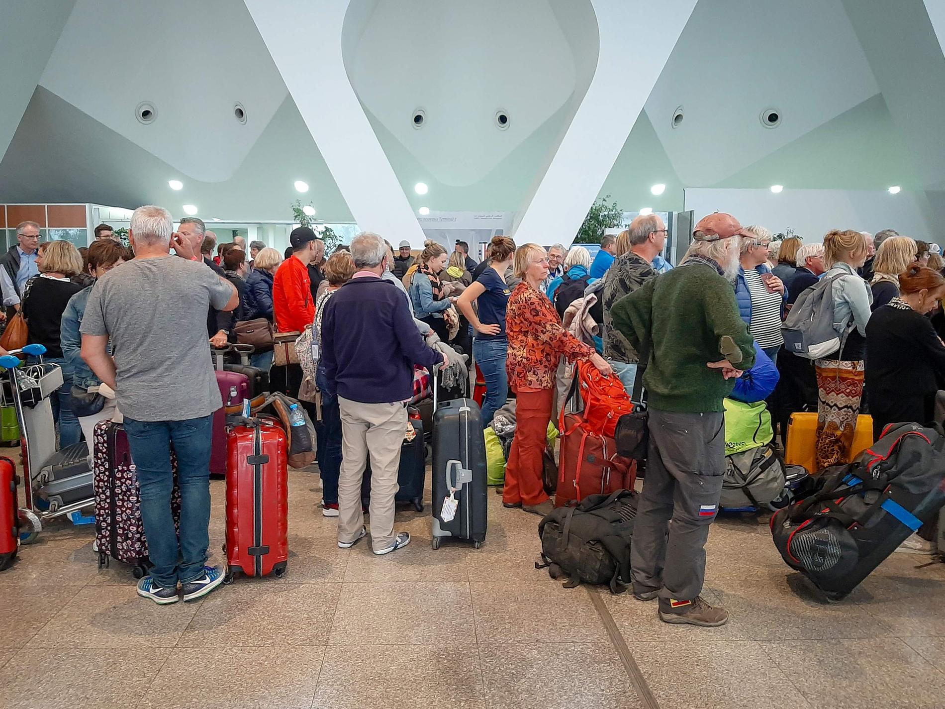 Passagerare köar på flygplatsen i Marrakesh på söndagen där flera specialchartrade plan hämtar hem tusentals strandsatta européer sedan Marocko ställt in alla reguljärflyg.