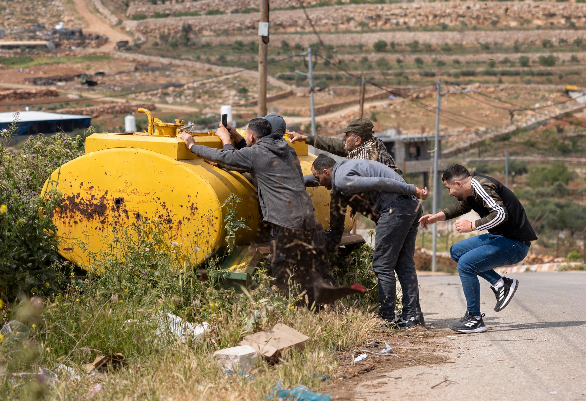 Kulorna viner farligt nära de palestinska männen som sökt skydd. 