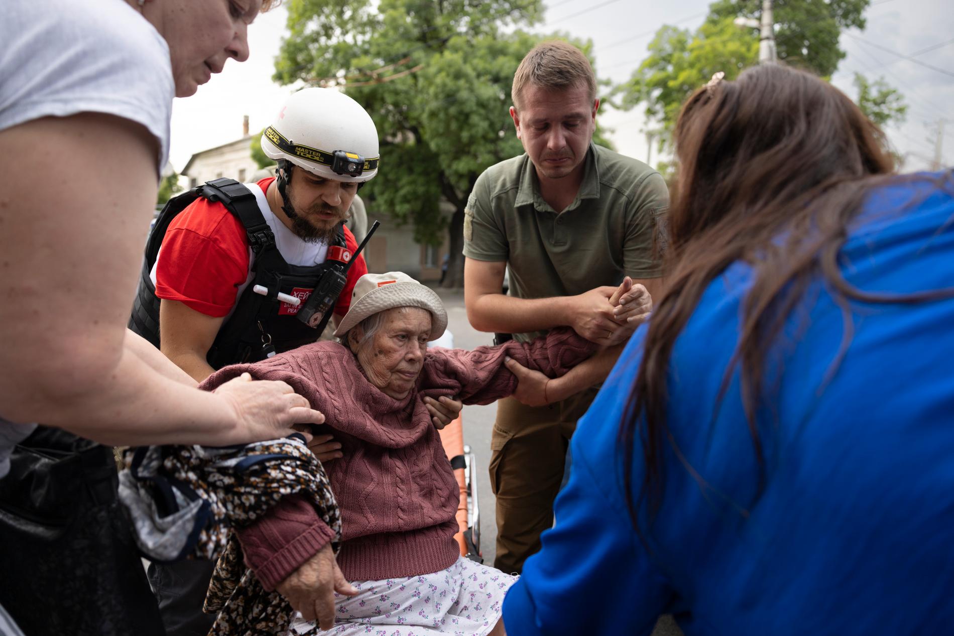 En kvinna som evakuerats får hjälp av räddningspersonal. 