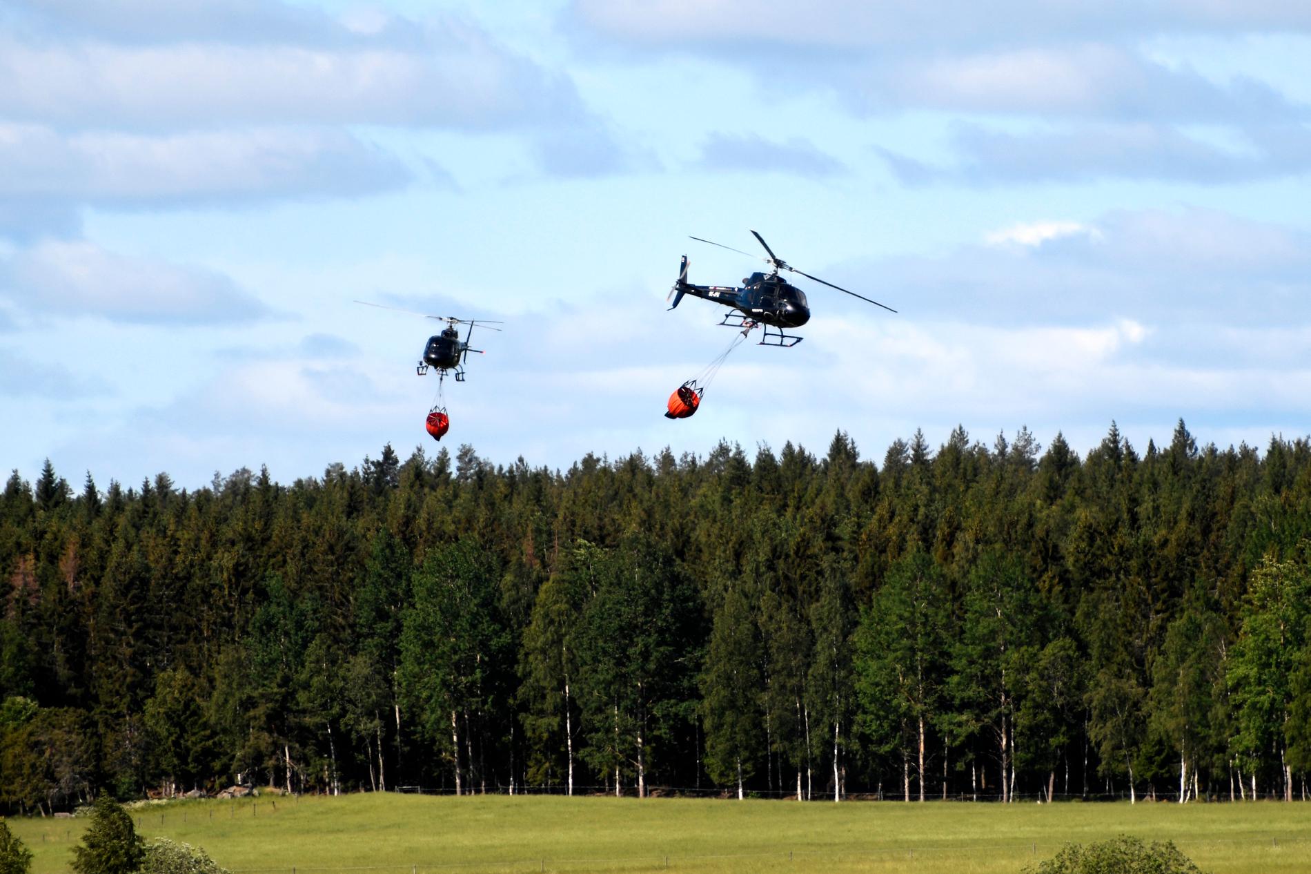 Fem helikoptrar jobbar med släckningsarbetet – fyra privata och en från Försvarsmakten – de samordnas med hjälp av en polishelikopter.
