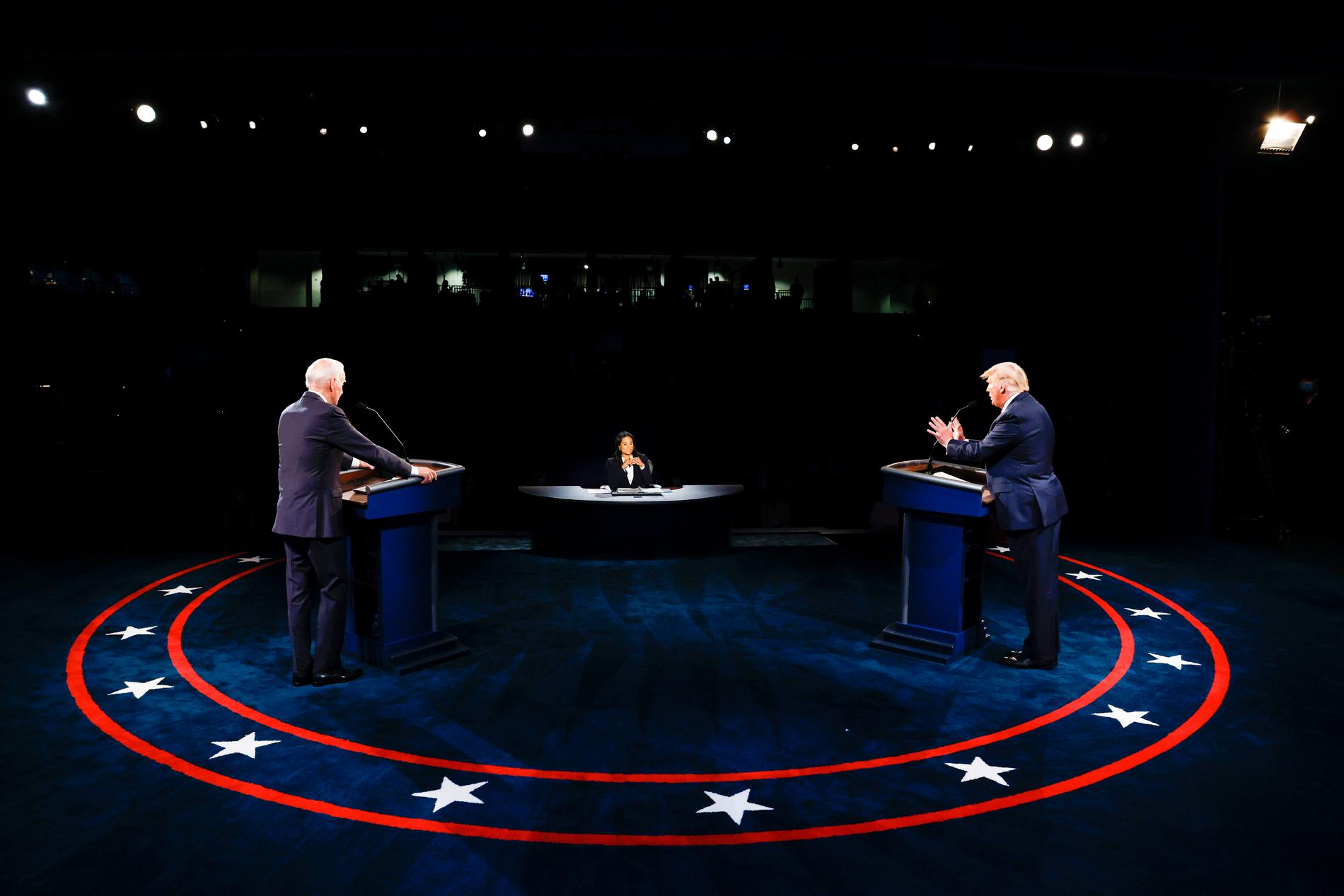 USA:s president Donald Trump och demokraternas presidentkandidat Joe Biden debatterar, med moderatorn Kristen Welker i mitten.