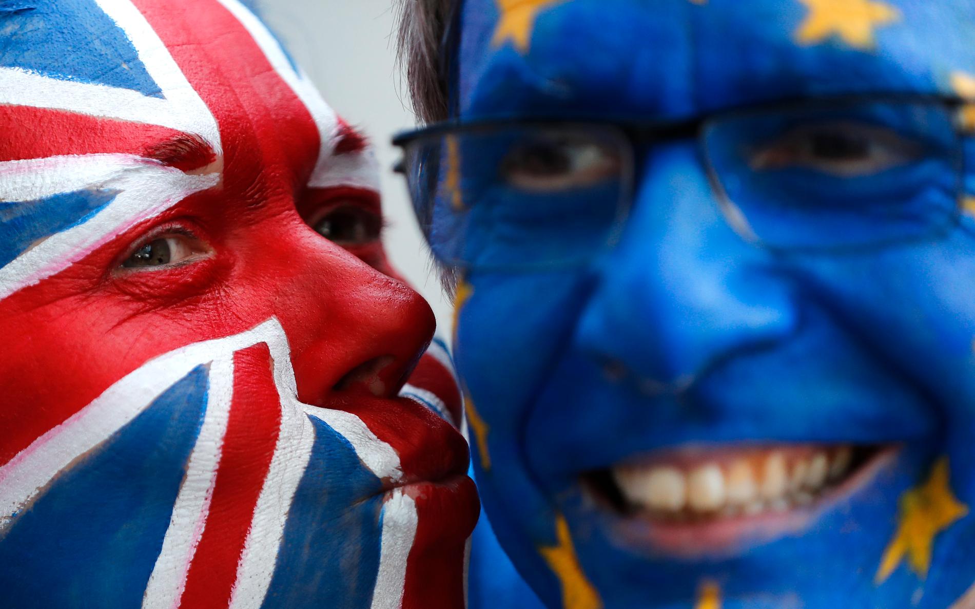 Flaggmålade aktivister pussas för att visa vänskapen mellan Storbritannien och EU utanför veckans EU-toppmöte i Bryssel.