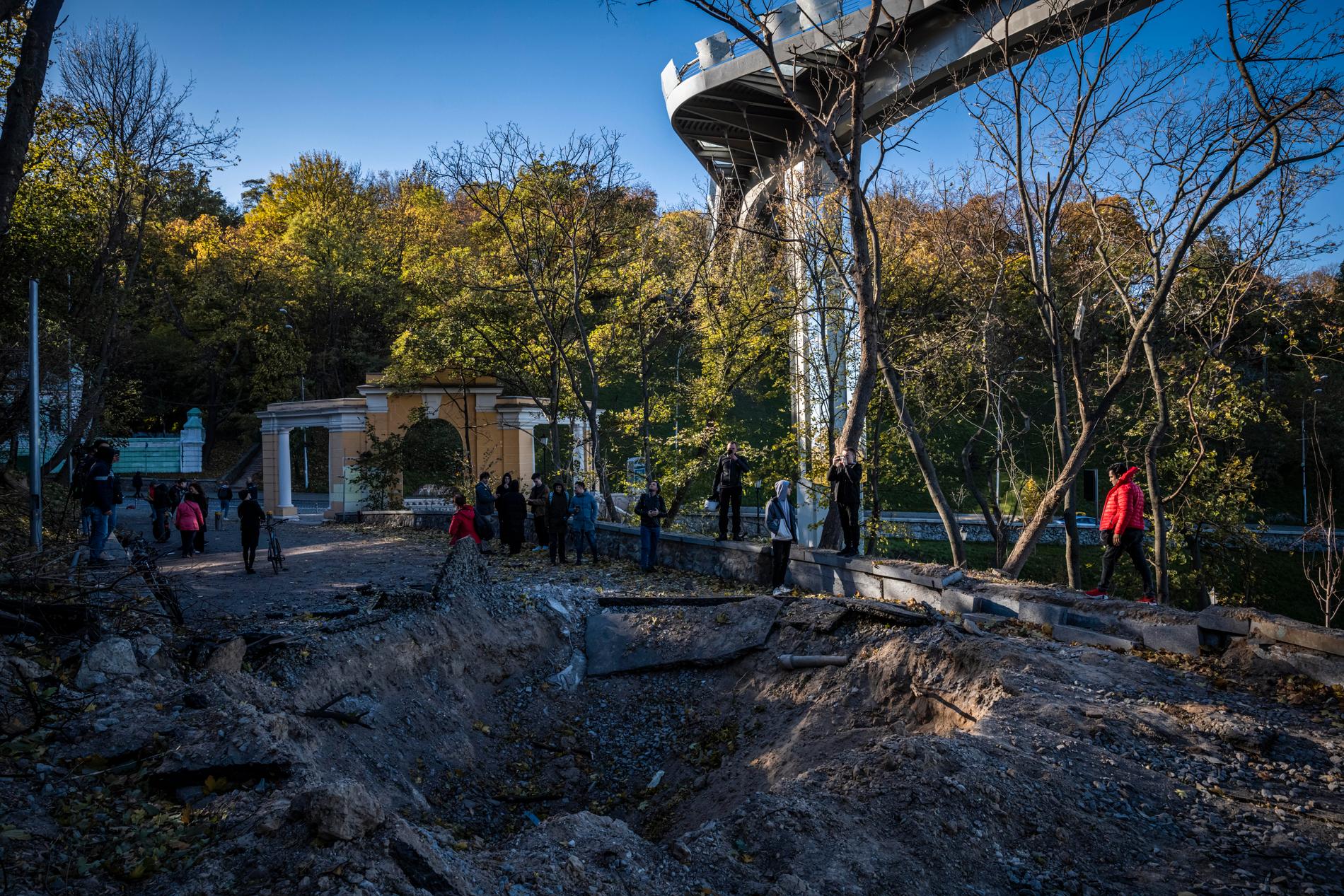Människor bevittnar förödelsen efter en explosion vid en gångbro över floden Dnepr i staden Dnipro.