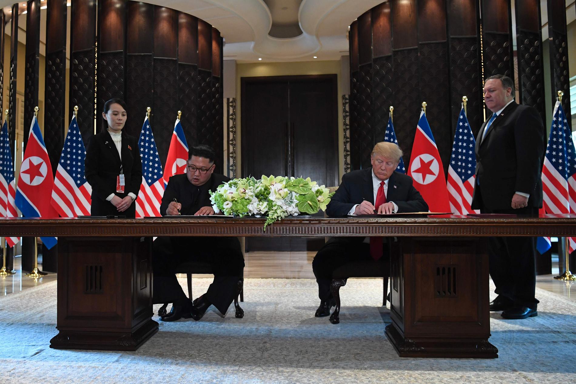 Här skriver Kim Jong-un och Trump under det historiska dokumentet. 