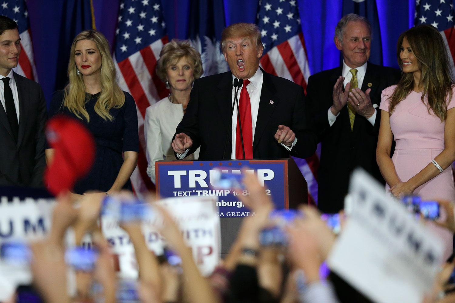 Trump håller sitt segertal flankerad av dottern Ivanka och hustrun Melania.