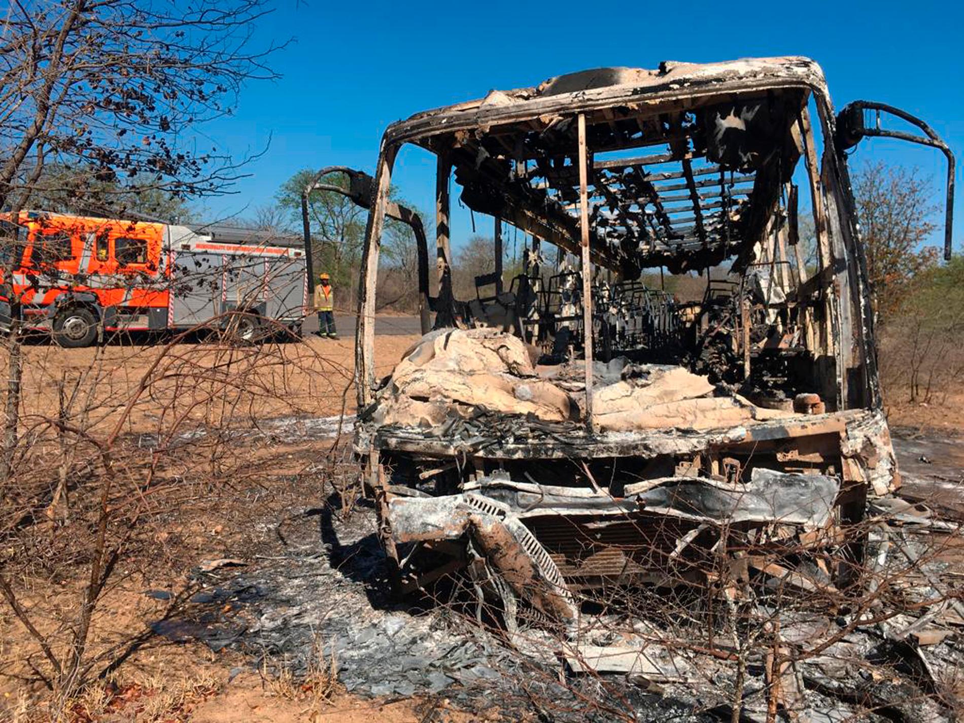 En brandbil parkerad i närheten av det utbrända vraket efter bussolyckan i närheten av Gwanda, omkring 55 mil söder om Zimbabwes huvudstad Harare, på fredagen.