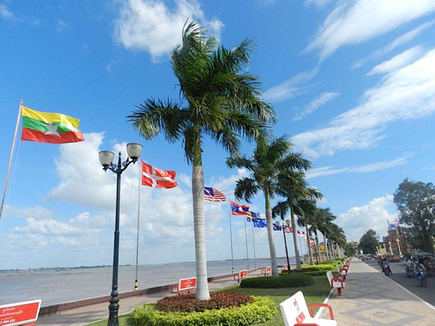 Strandpromenaden i Phnom Penh kantas av vackra palmer och ett 70-tal av världens flaggor, bland annat den svenska.