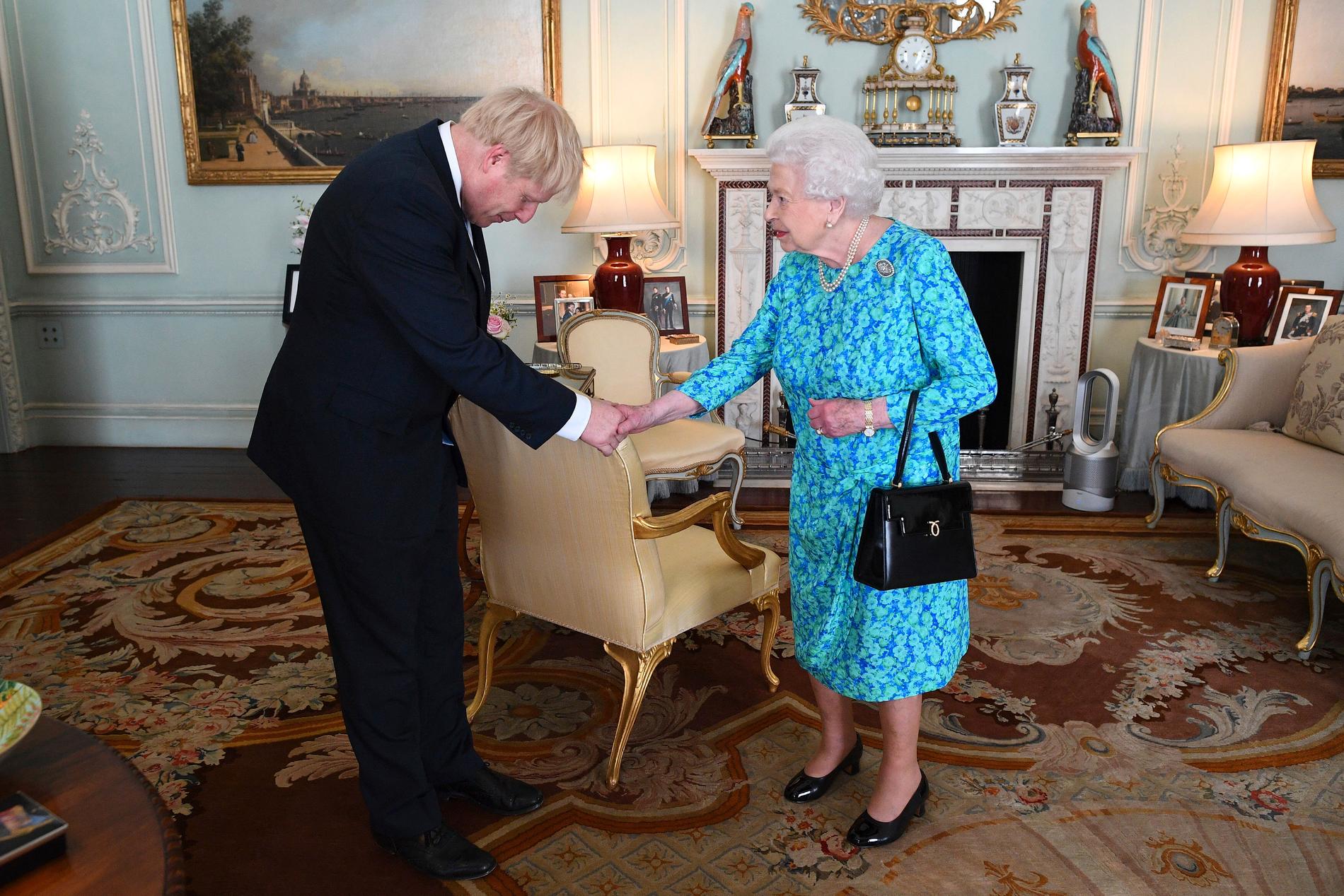 Boris Johnson bugar när han hälsar på Elizabeth II.