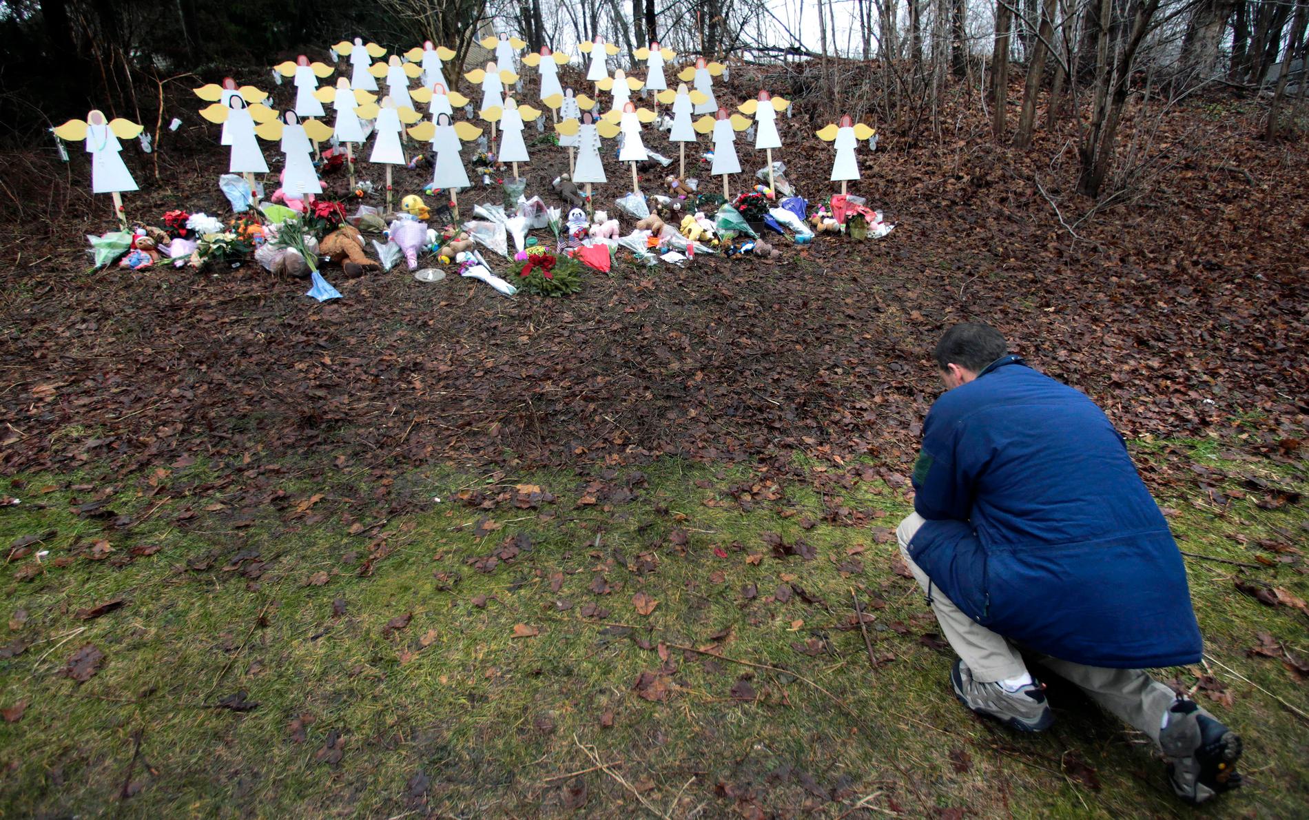 En man hedrar offren vid den minnesplatsen efter Sandy Hook-massakern. Arkivbild.