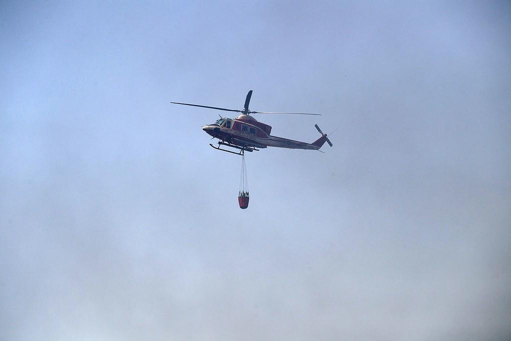 Helikopter transporterar vatten till området. 