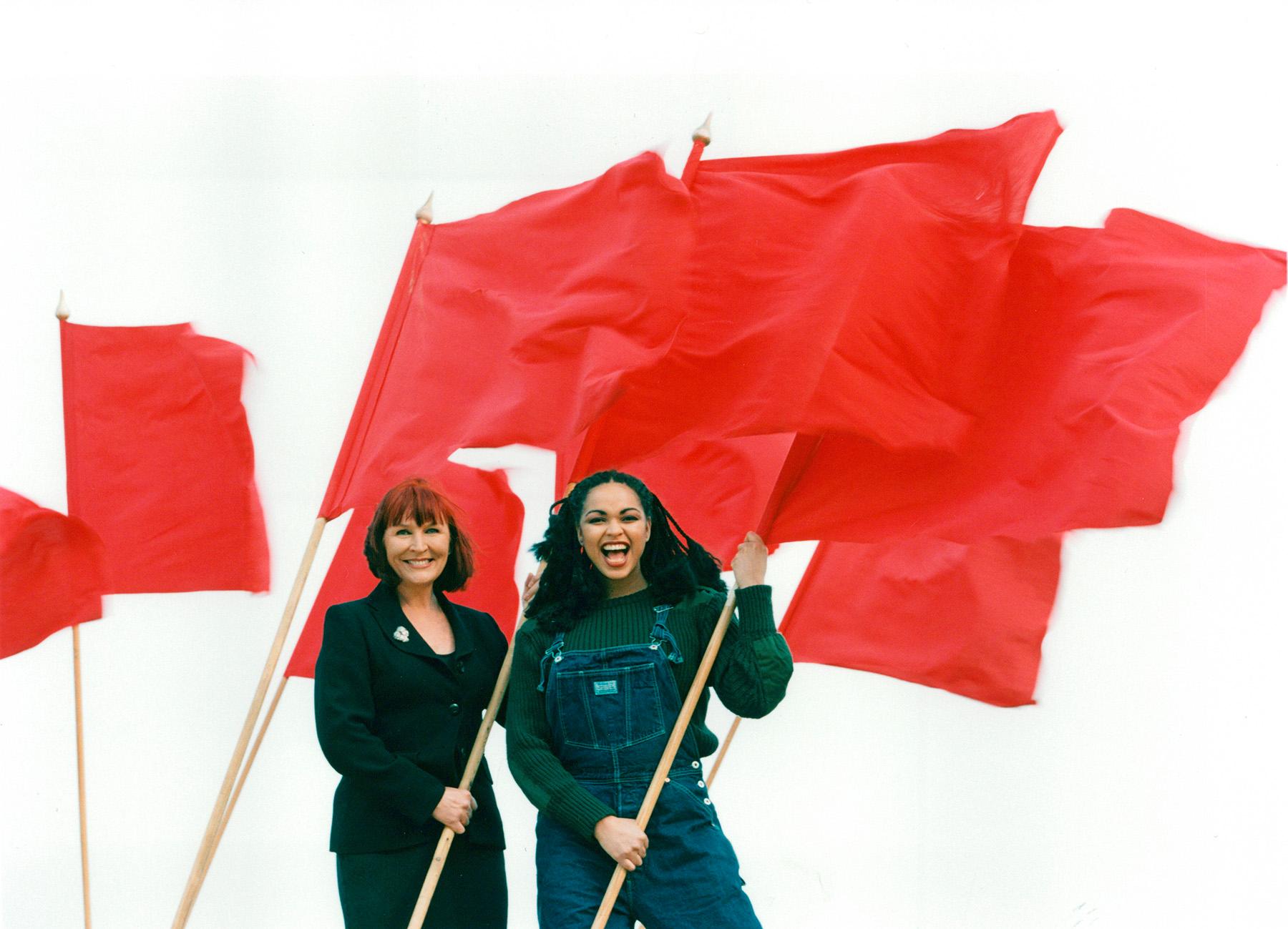 Kim Anderzon och Camilla Henemark med röda fanor. De Första Maj talade 1996.