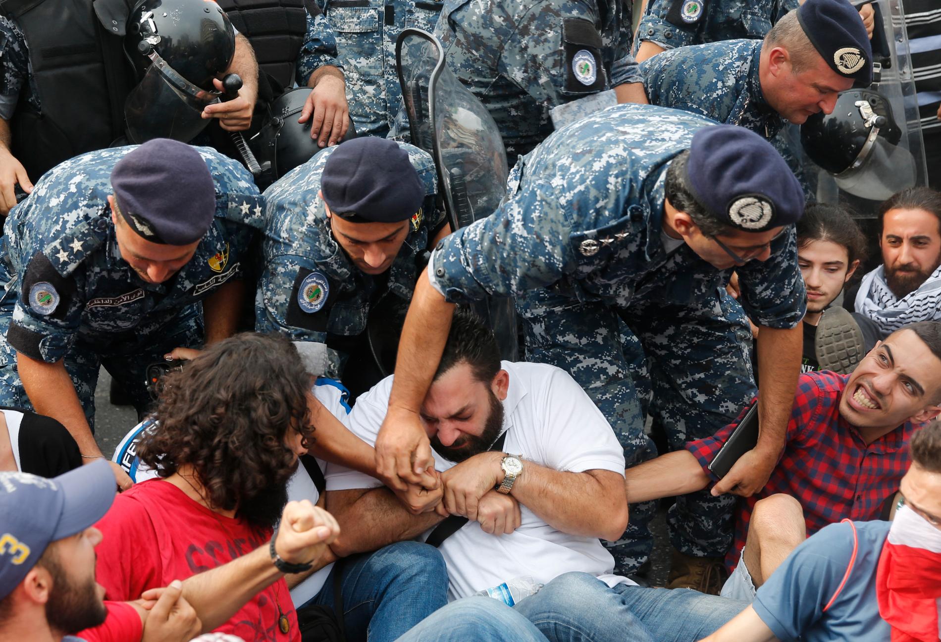 Libanesiska kravallpoliser flyttar på demonstranter som blockerat en motorväg i huvudstaden Beirut på lördagen.