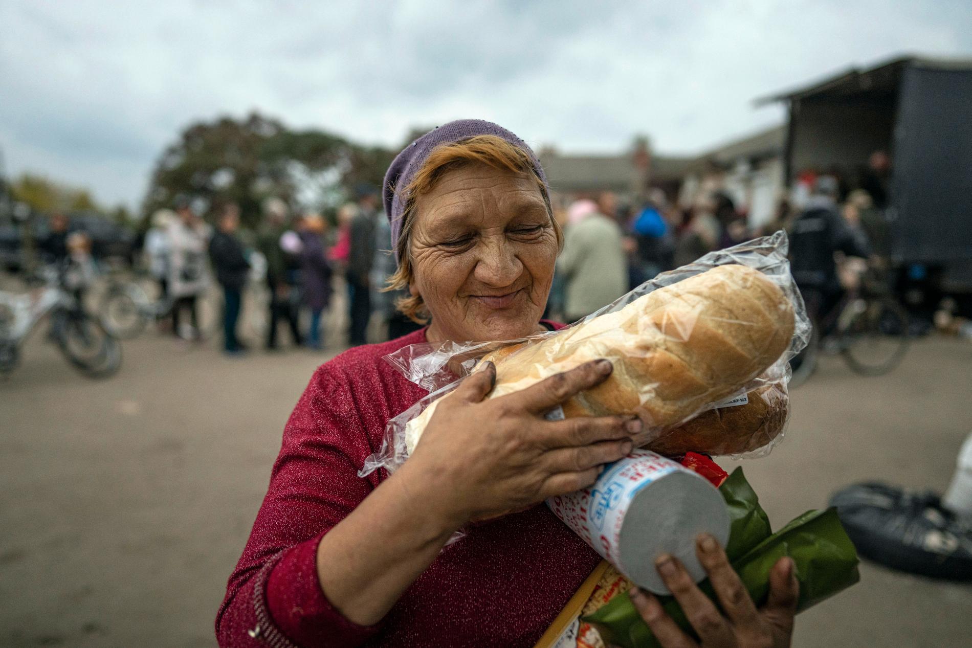 2 OKTOBER: Två limpor bröd kan göra skillnad. En kvinna var glad efter att hon fått humanitär hjälp i Izium.