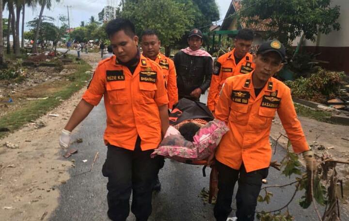 Räddningspersonal bär en överlevare på bår. Minst 222 personer har dött efter att en tsunami nådde stränderna vid Sundasundet i Indonesien.