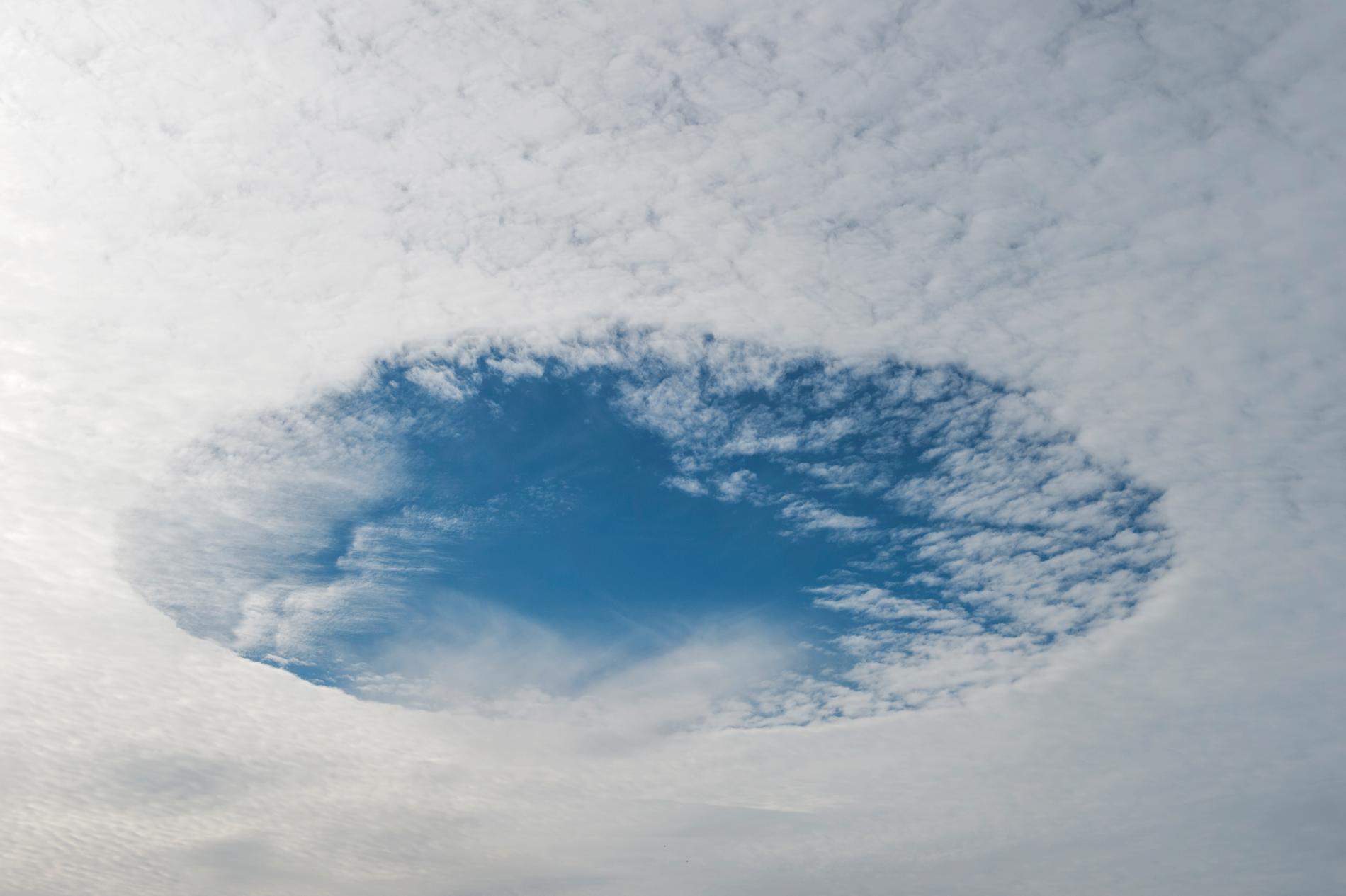 Misstänkta ufo-observationer visar sig ibland vara molnformationer. Denna, av blå himmel som en rund fläck i ett hål i molntäcket, fotades över Brunna i Upplands Bro i Sverige.