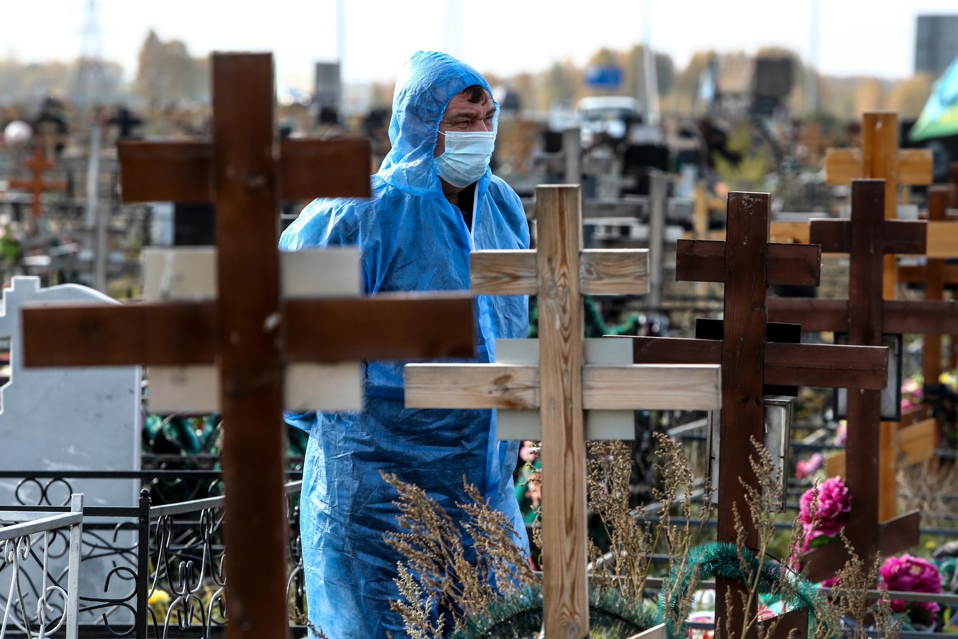 En gravgrävare bär skyddskläder utanför Omsk, Ryssland. 