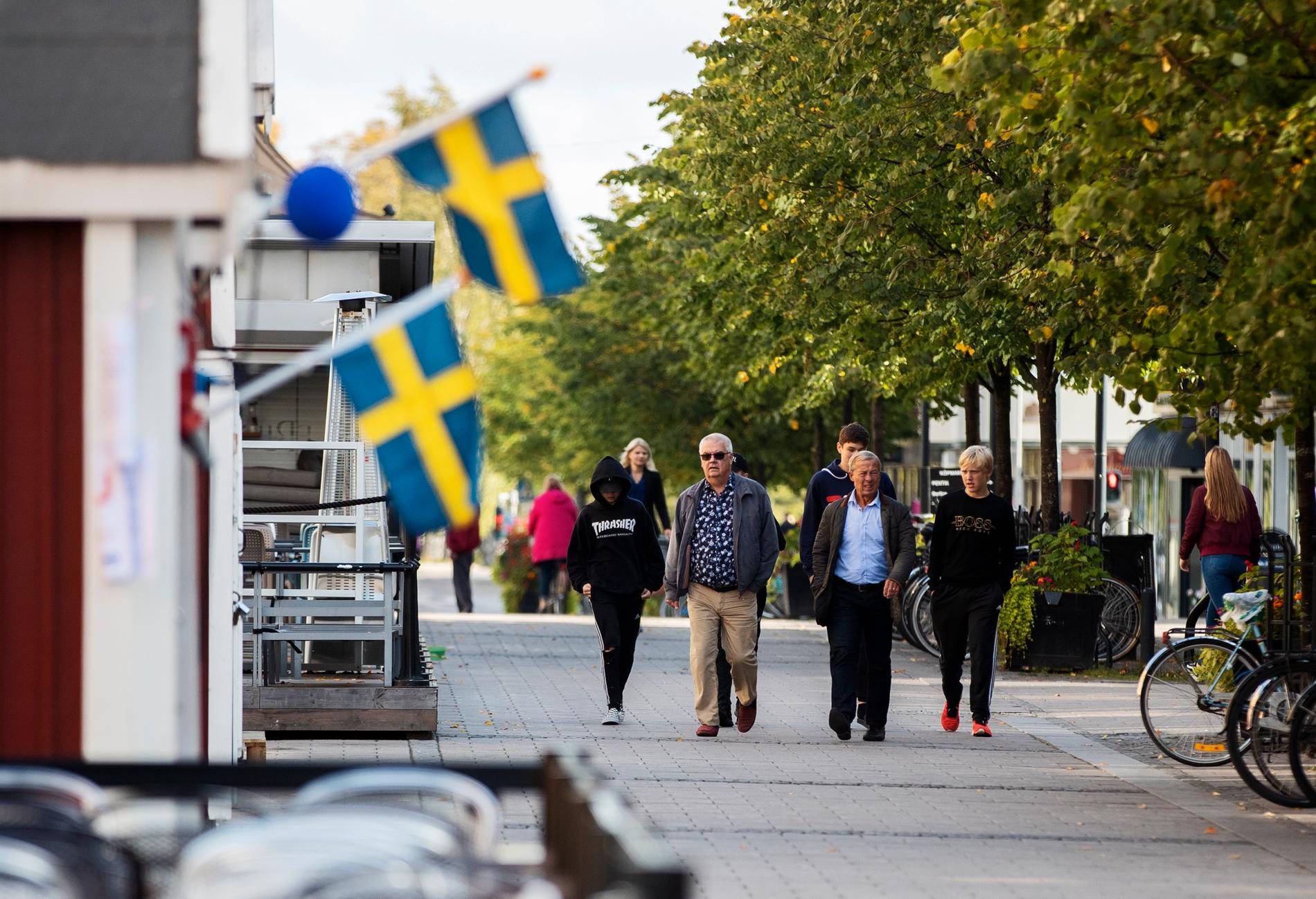 Människor promenerar förbi valstugorna på gågatan i Luleå.