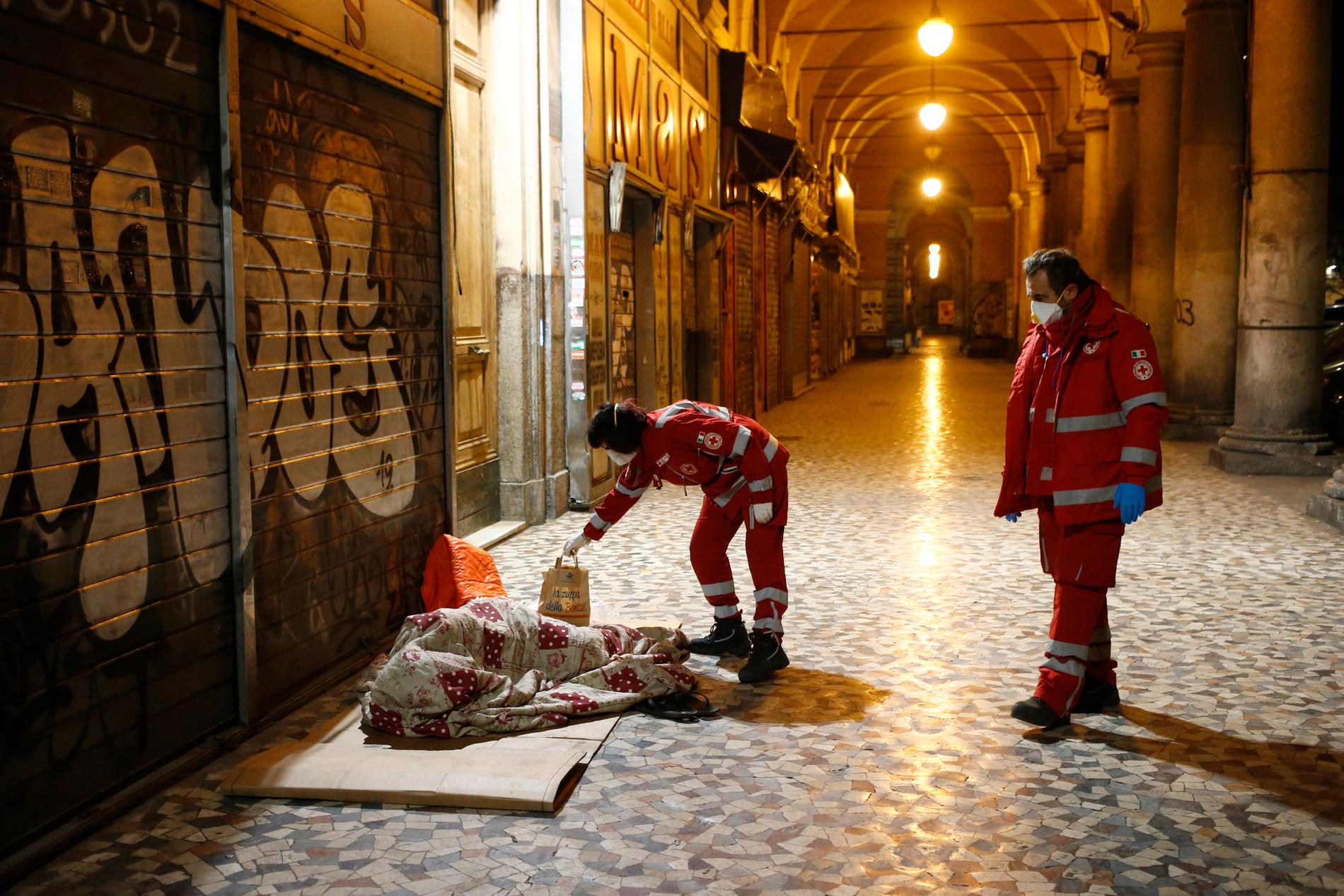 ROM, ITALIEN  Hemlös i Rom får mat och desinfektionsmedel från Röda Korset-medarbetare på lördagen.