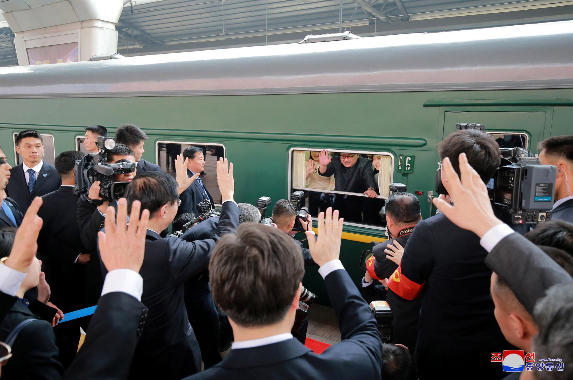 Kim Jong-un vinkar från tåget på tågstationen i Beijing. 