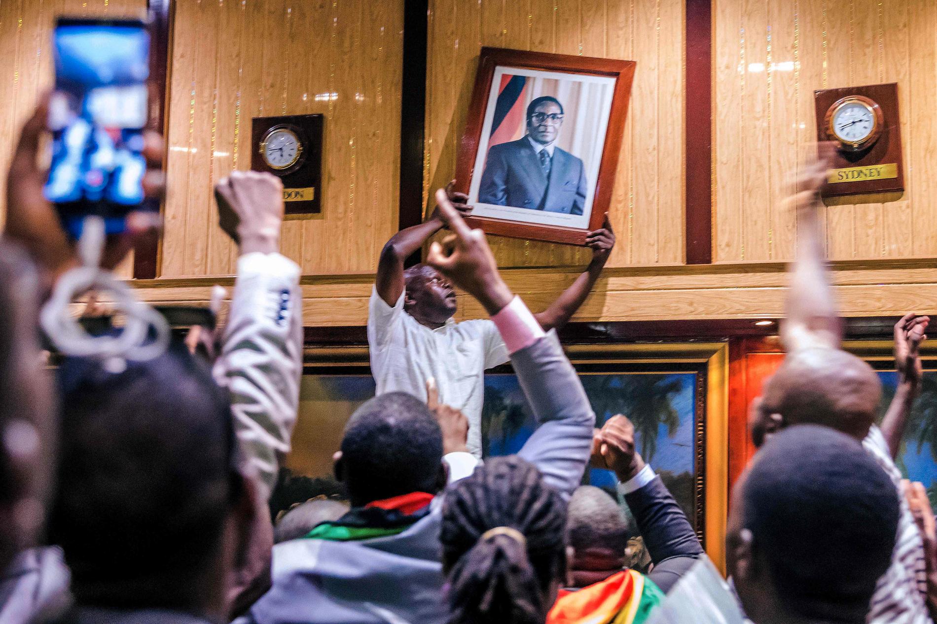 Porträtt av Robert Mugabe slits ner i parlamentet efter besked om hans avgång.