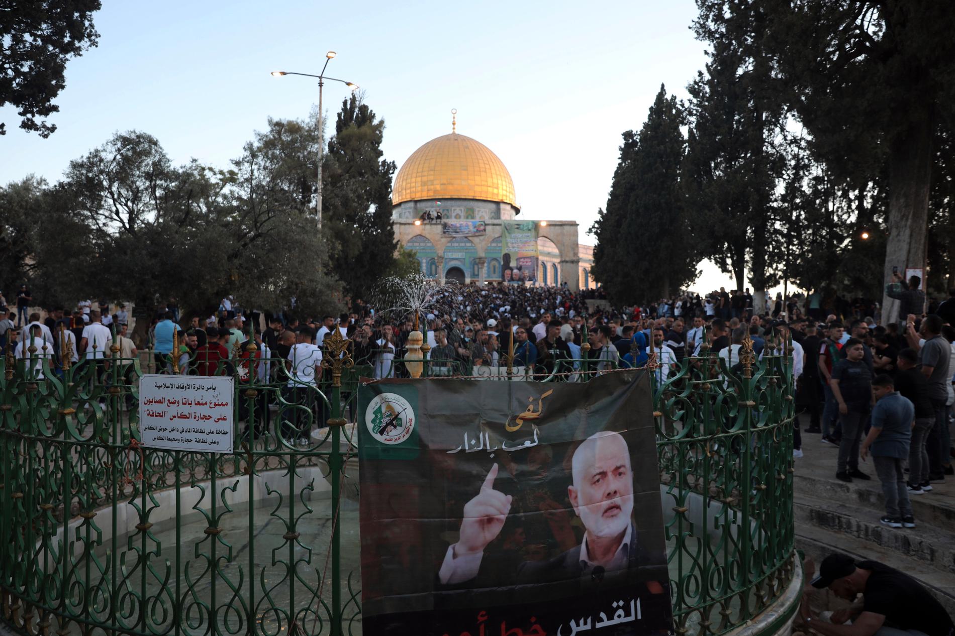 Samtidigt som konflikten rasar firar nu muslimerna storhelgen id al-fitr. Här syns en banderoll med Hamasledaren Ismail Haniya vid Klippmoskén i Jerusalem.