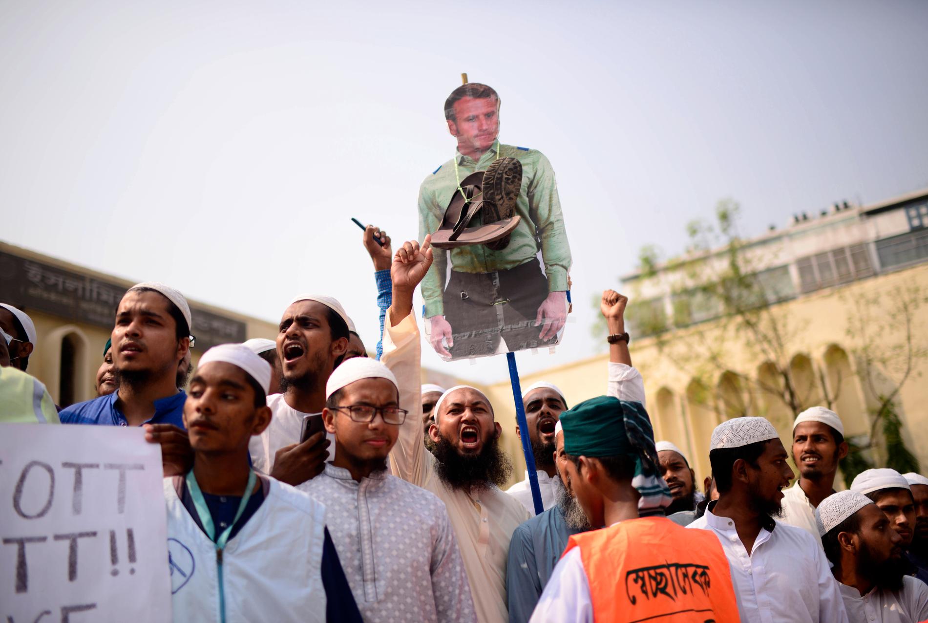 Dhakabor protesterar mot Frankrikes president Emmanuel Macron.